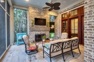Brick fireplace, porcelain tile floors, and mahogany doors. A screened porch with a brick fireplace and sitting area.