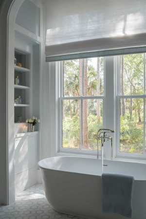 Bathroom in a Palmetto Bluff home built by CS Thomas Construction with soaking tub and large windows overlooking trees.
