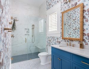 Guest bathroom in Palmetto Bluff with glass shower and patterned wallpaper.