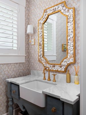 Powder room in Palmetto Bluff with oyster shell mirror and marble countertop.