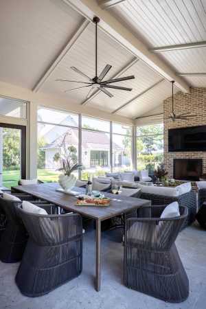 Details: vaulted ceiling, v-groove ceiling, old-world tabby tile, brick fireplace. Screened porch with dining area, brick fireplace, and vaulted ceiling in Palmetto Bluff home.