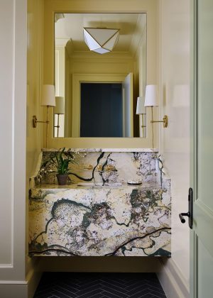 Powder room with bold natural stone vanity, brass fixtures, and warm neutral tones in a Palmetto Bluff custom home.