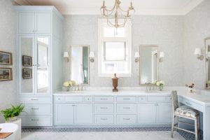 Elegant bathroom with dual vanities, marble counters, and light blue cabinetry in Palmetto Bluff home.